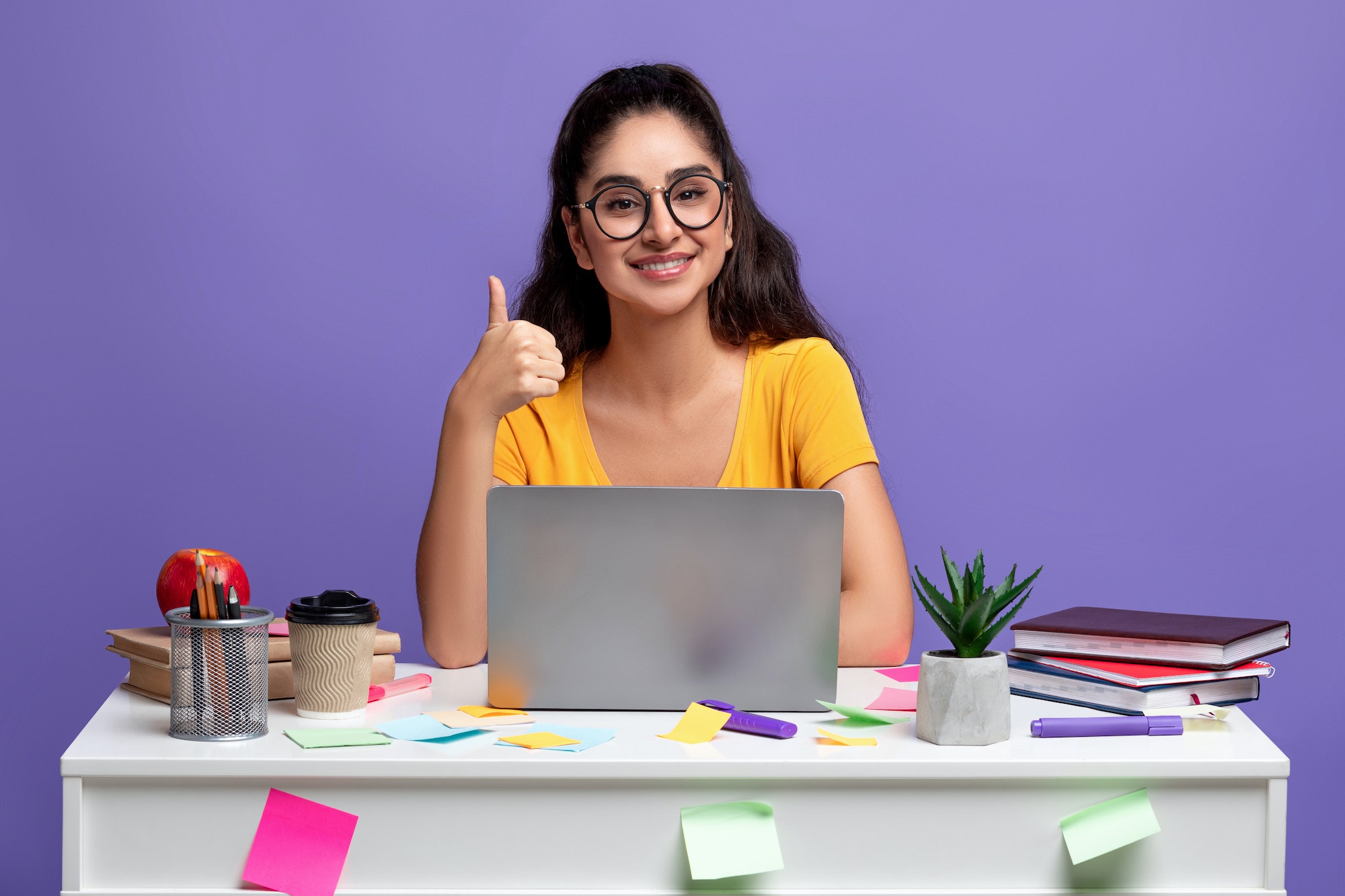 Indian woman using laptop showing thumbs up gesture